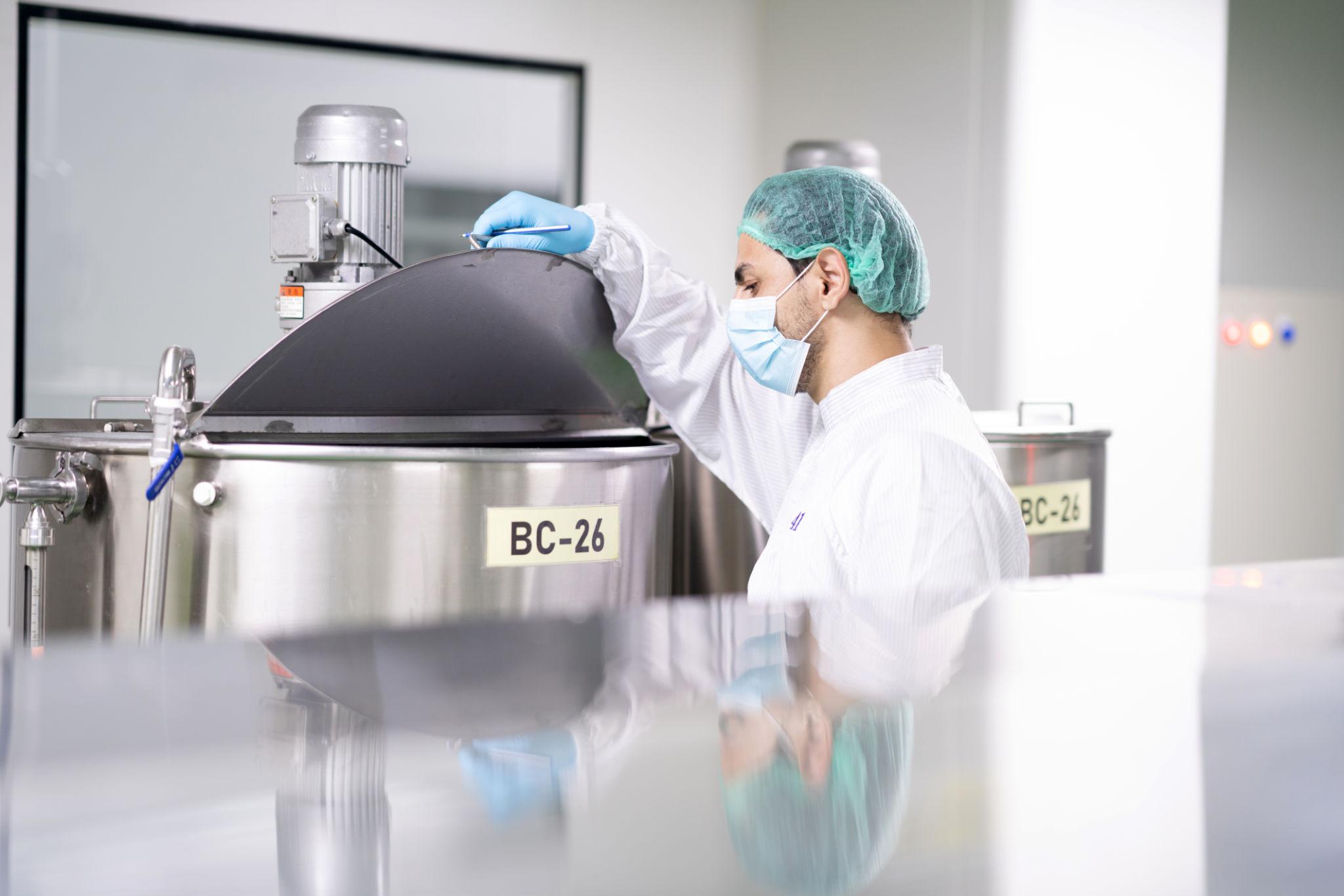 Cleanroom technician inspecting medical manufacturing equipment